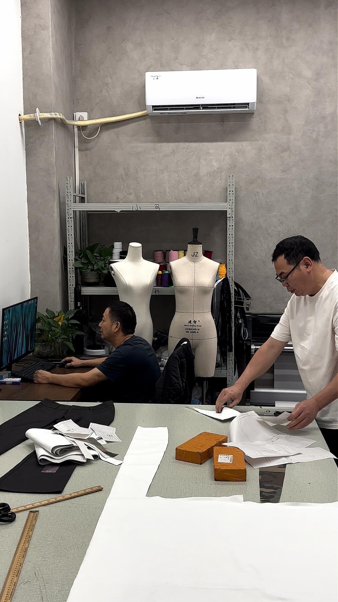 Pattern maker reviewing paper patterns in the HUYU Apparel sample room